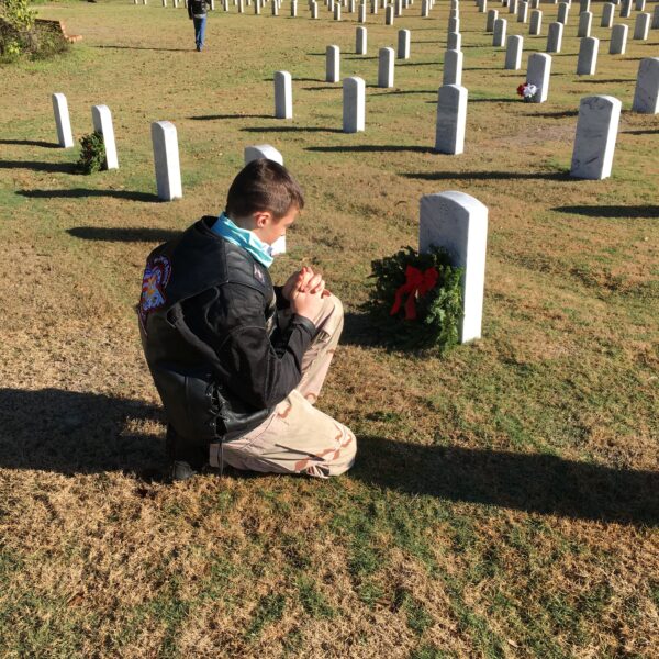 Wayland Gray praying over Veteran grave